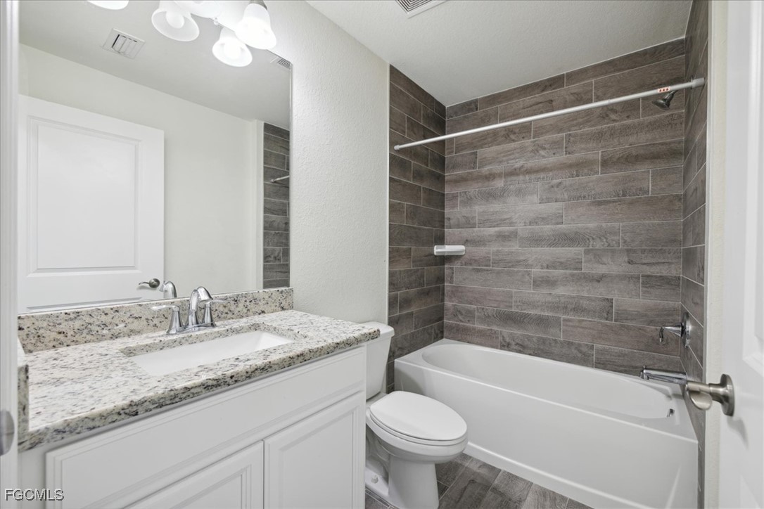 2914 Flora Avenue North Lehigh Acres, FL 33971 - Photo 25 of 39 a bathroom with a granite countertop sink toilet and shower