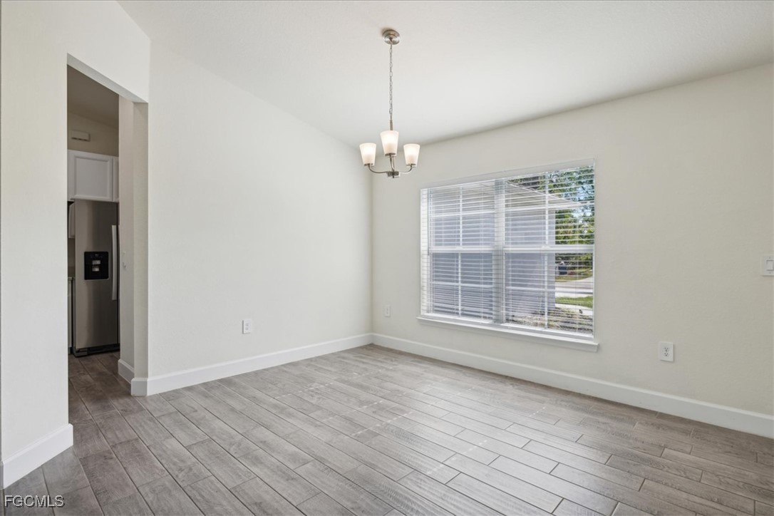 2914 Flora Avenue North Lehigh Acres, FL 33971 - Photo 3 of 39 an empty room with wooden floor cabinet and windows