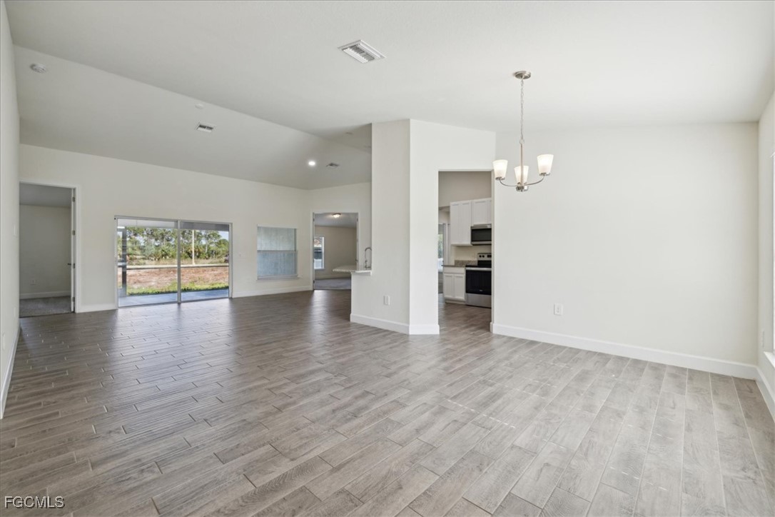 2914 Flora Avenue North Lehigh Acres, FL 33971 - Photo 4 of 39 a view of an empty room with a window and wooden floor