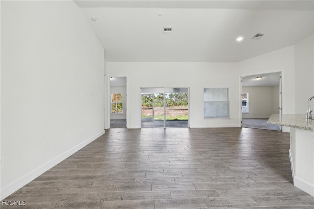 2914 Flora Avenue North Lehigh Acres, FL 33971 - Photo 6 of 39 a view of an empty room with window and wooden floor