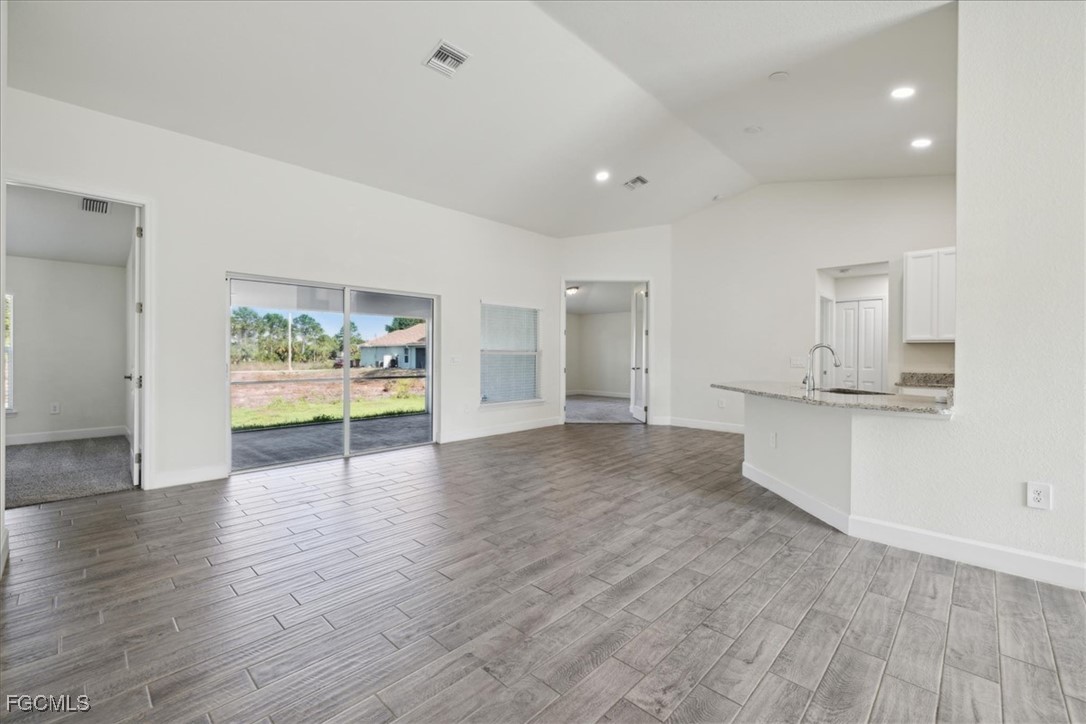 2914 Flora Avenue North Lehigh Acres, FL 33971 - Photo 7 of 39 a view of an empty room with wooden floor and a window