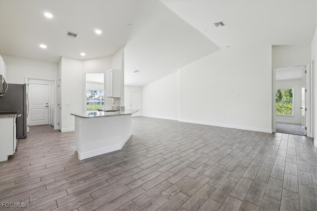 2914 Flora Avenue North Lehigh Acres, FL 33971 - Photo 9 of 39 a view of kitchen with cabinets and wooden floor