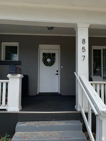 857 27th Street Ogden, UT 84403 - Photo 3 of 20 Front porch featuring a white entry door with frosted glass paneling, a dark grey painted brick facade, white trim, and white porch columns