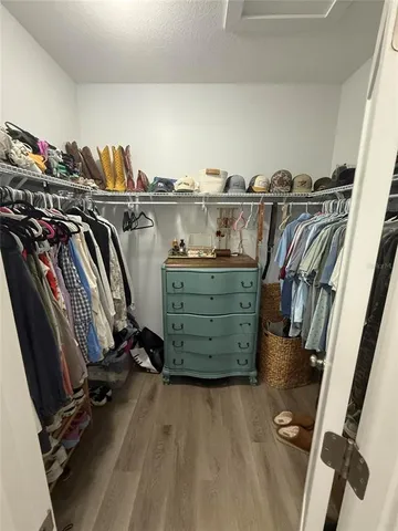 a view of walk in closet with clothes and shoes