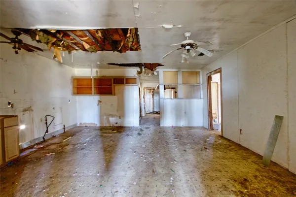 en empty room with ceiling fan and window