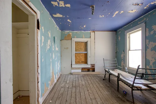 a view of a hallway with wooden floor and furniture