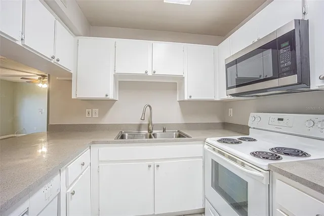a kitchen with appliances a sink and cabinets