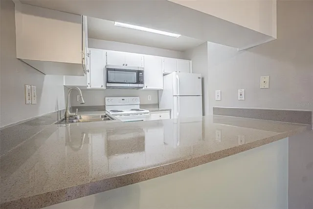 a kitchen with kitchen island a stove a sink and a refrigerator