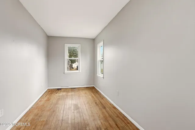 a view of a room with wooden floor and window