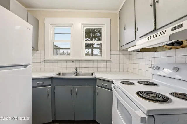 a kitchen with a sink a stove and cabinets