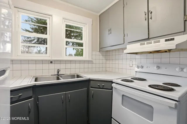 a kitchen with a sink stove and cabinets