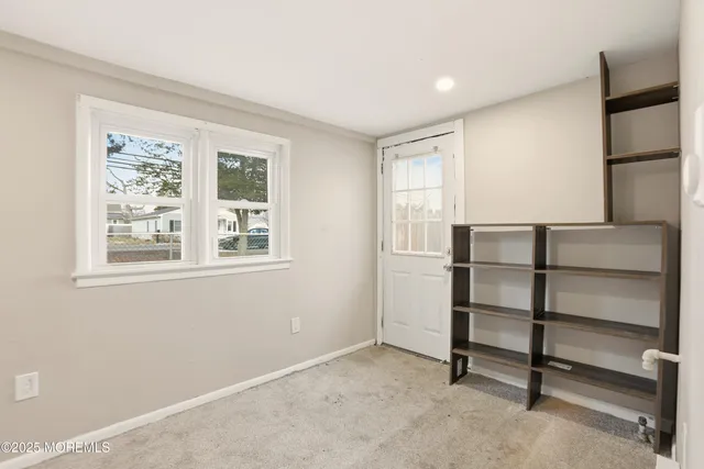 a view of an empty room with closet and a window