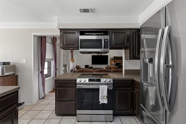 a kitchen with stainless steel appliances granite countertop a stove a refrigerator and a microwave
