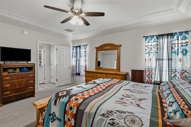 a bedroom with a bed and a flat tv screen on dresser