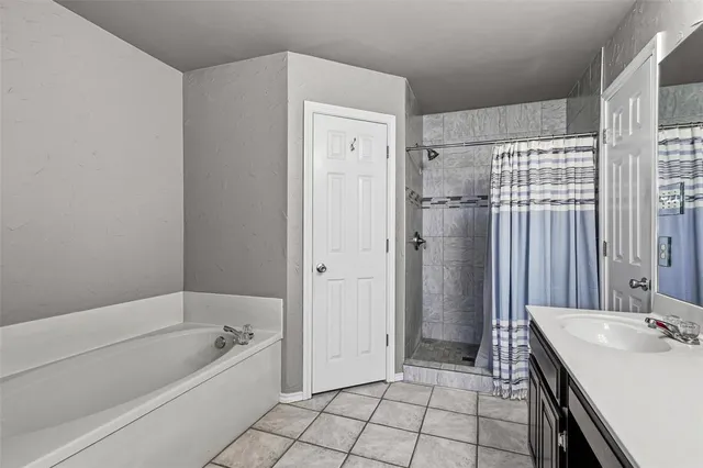 a bathroom with a tub a sink and a shower