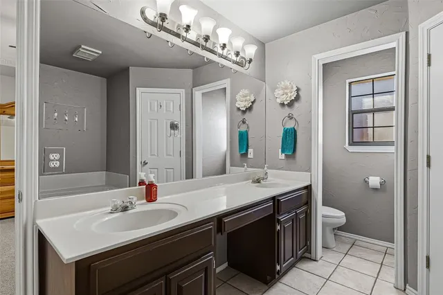a bathroom with a sink double vanity and a toilet
