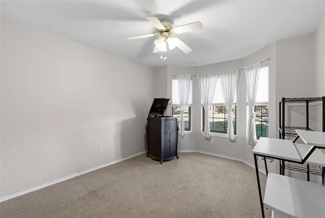 a view of a room with a ceiling fan and a bathroom