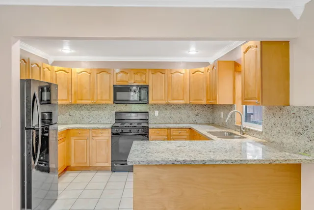 a view of a kitchen with furniture and stainless steel appliances