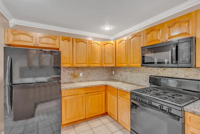 a kitchen with stainless steel appliances granite countertop a sink refrigerator and microwave