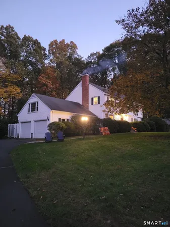a view of an house next to a big yard with large trees