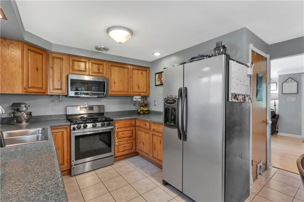 391 Wendel Road Irwin, PA 15642 - Photo 11 of 32 a kitchen with stainless steel appliances granite countertop a refrigerator stove and sink