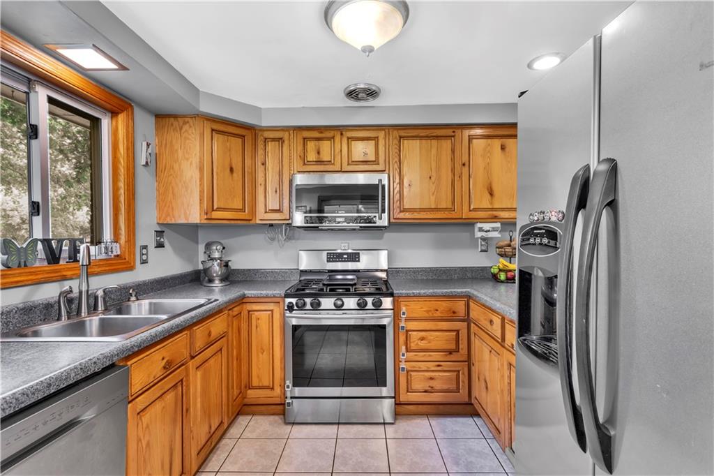 391 Wendel Road Irwin, PA 15642 - Photo 12 of 32 a kitchen with stainless steel appliances granite countertop a stove a sink a refrigerator and a microwave