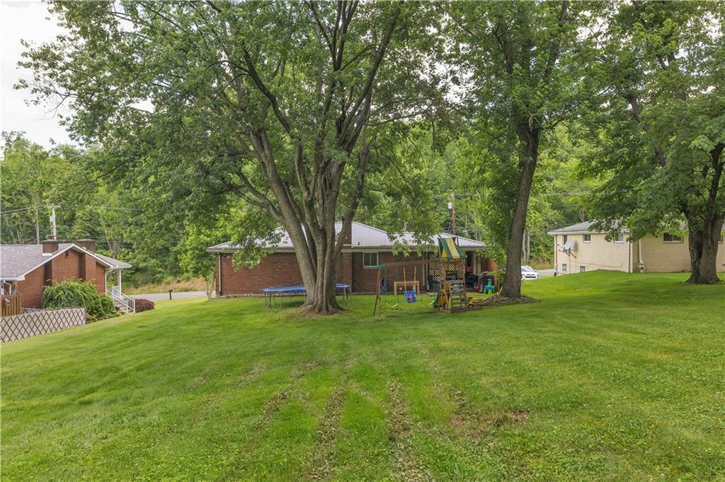 391 Wendel Road Irwin, PA 15642 - Photo 30 of 32 a view of a yard with plants and a bench