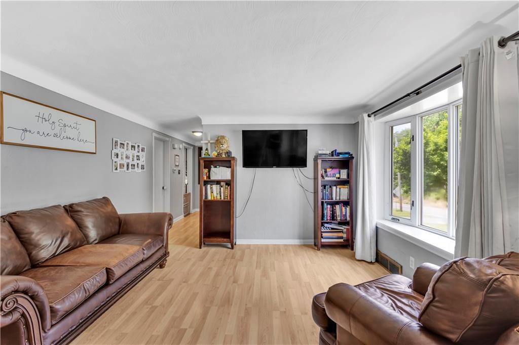 391 Wendel Road Irwin, PA 15642 - Photo 5 of 32 a living room with a couch and a flat screen tv