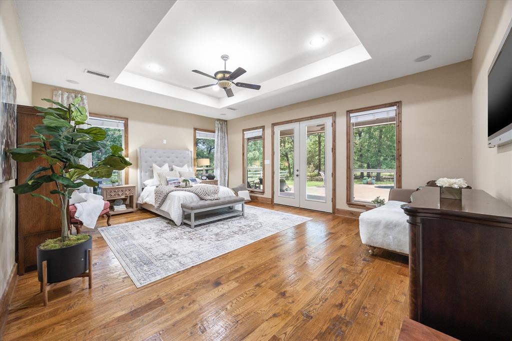2702 Hidden Trails Road Royse City, TX 75189 - Photo 17 of 39 a bedroom with a bed couch and a large window with wooden floor