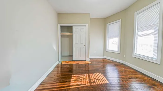 a view of a room with wooden floor and window