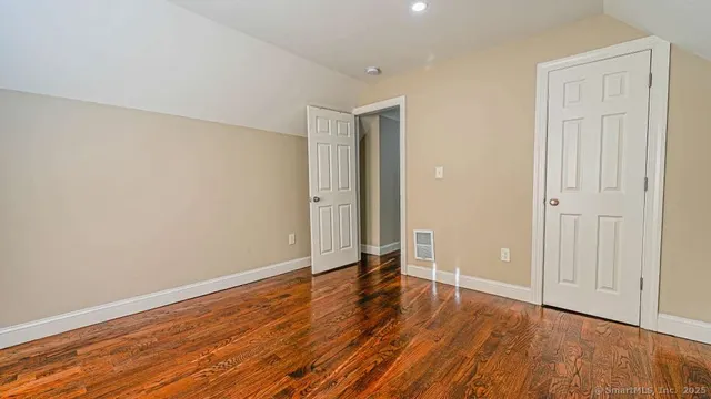 a view of an empty room with wooden floor