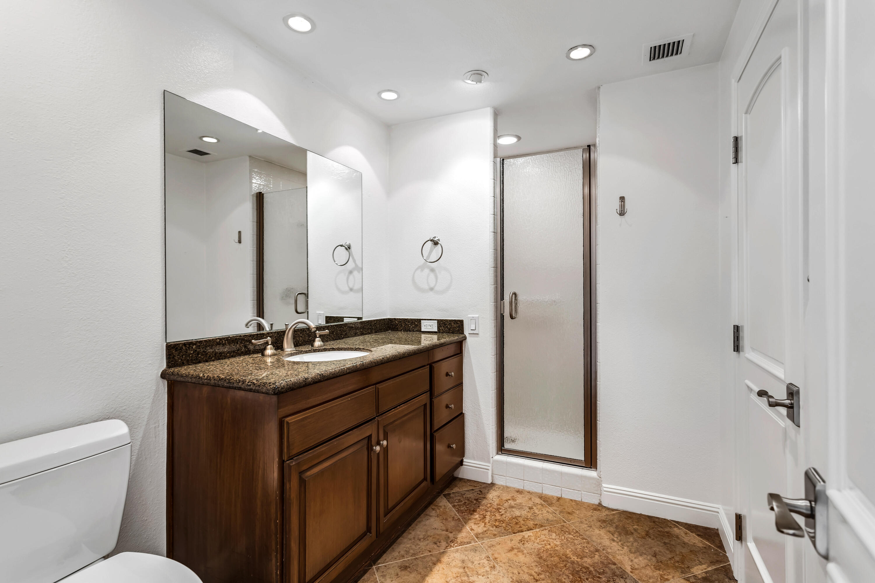 910 Island Drive, Unit 211 Rancho Mirage, CA 92270 - Photo 22 of 38 a bathroom with a granite countertop sink a toilet a mirror and shower