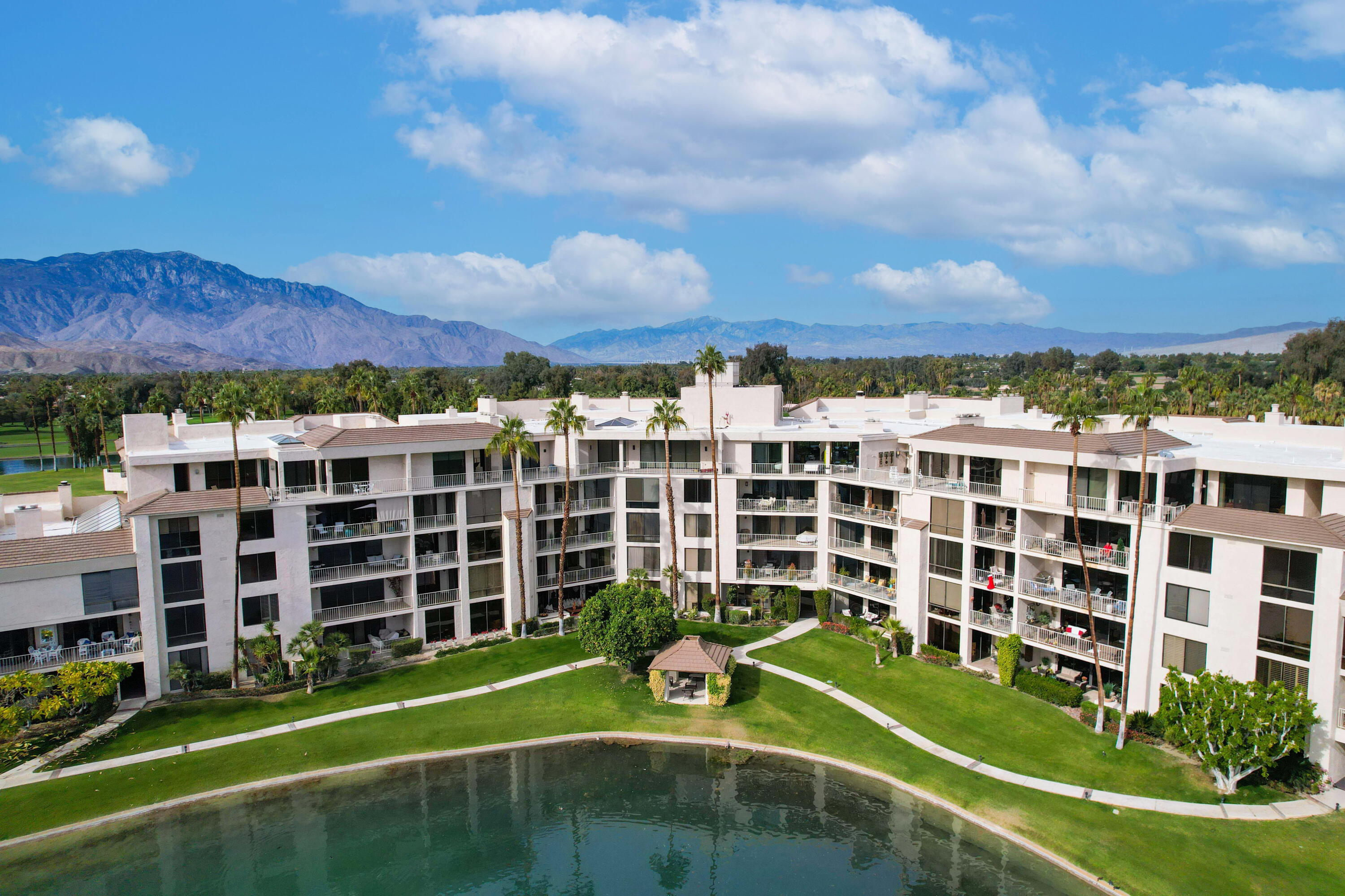 910 Island Drive, Unit 211 Rancho Mirage, CA 92270 - Photo 33 of 38 a view of a building with a big yard and potted plants