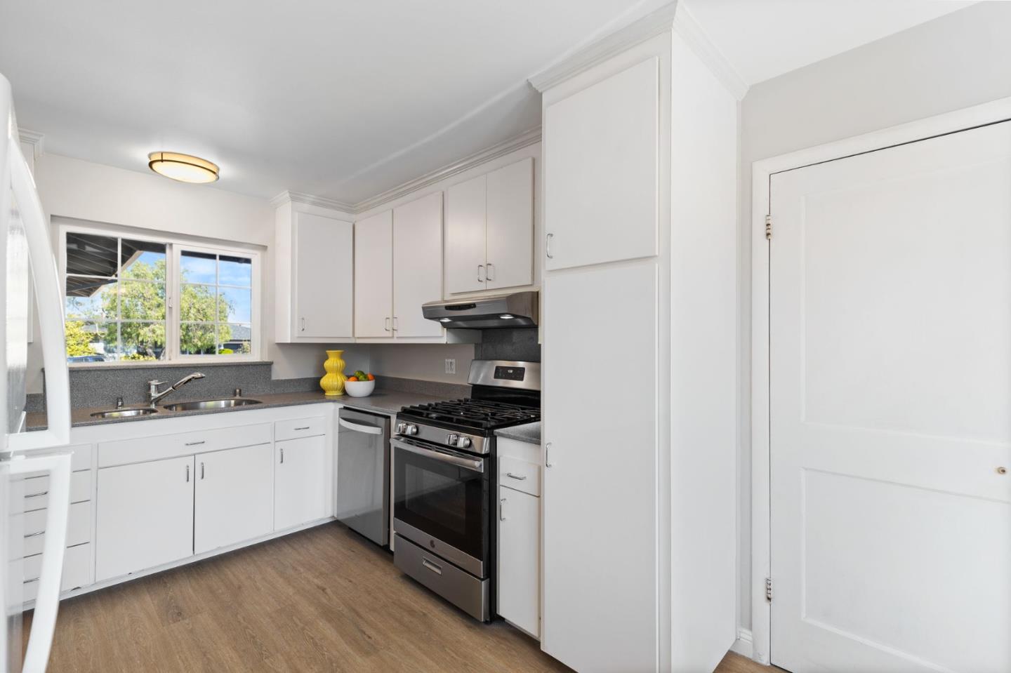 228 Spuraway Drive San Mateo, CA 94403 - Photo 9 of 20 a kitchen with stainless steel appliances a sink cabinets and a window