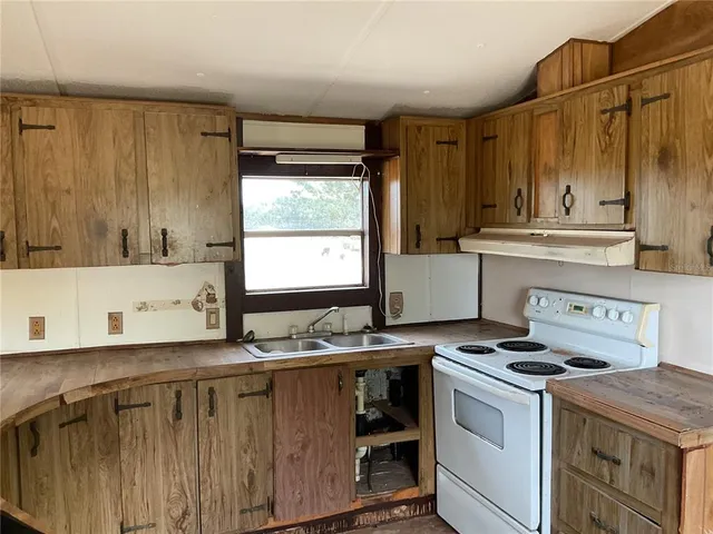 a kitchen with stainless steel appliances a stove a sink and a microwave