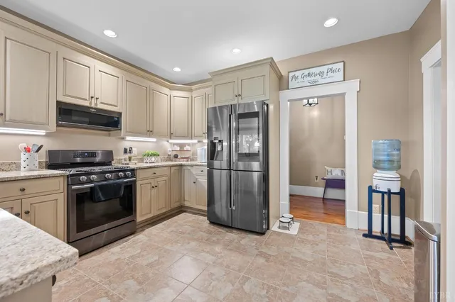 a bedroom with a bed chandelier and a window