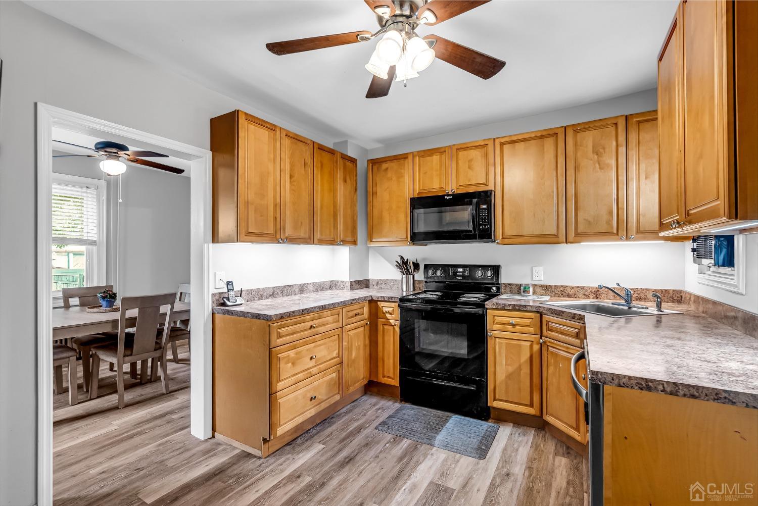 40 Farrington Road Old Bridge, NJ 07747 - Photo 11 of 49 a kitchen with stainless steel appliances granite countertop a stove top oven a sink dishwasher a dining table and chairs with wooden floor