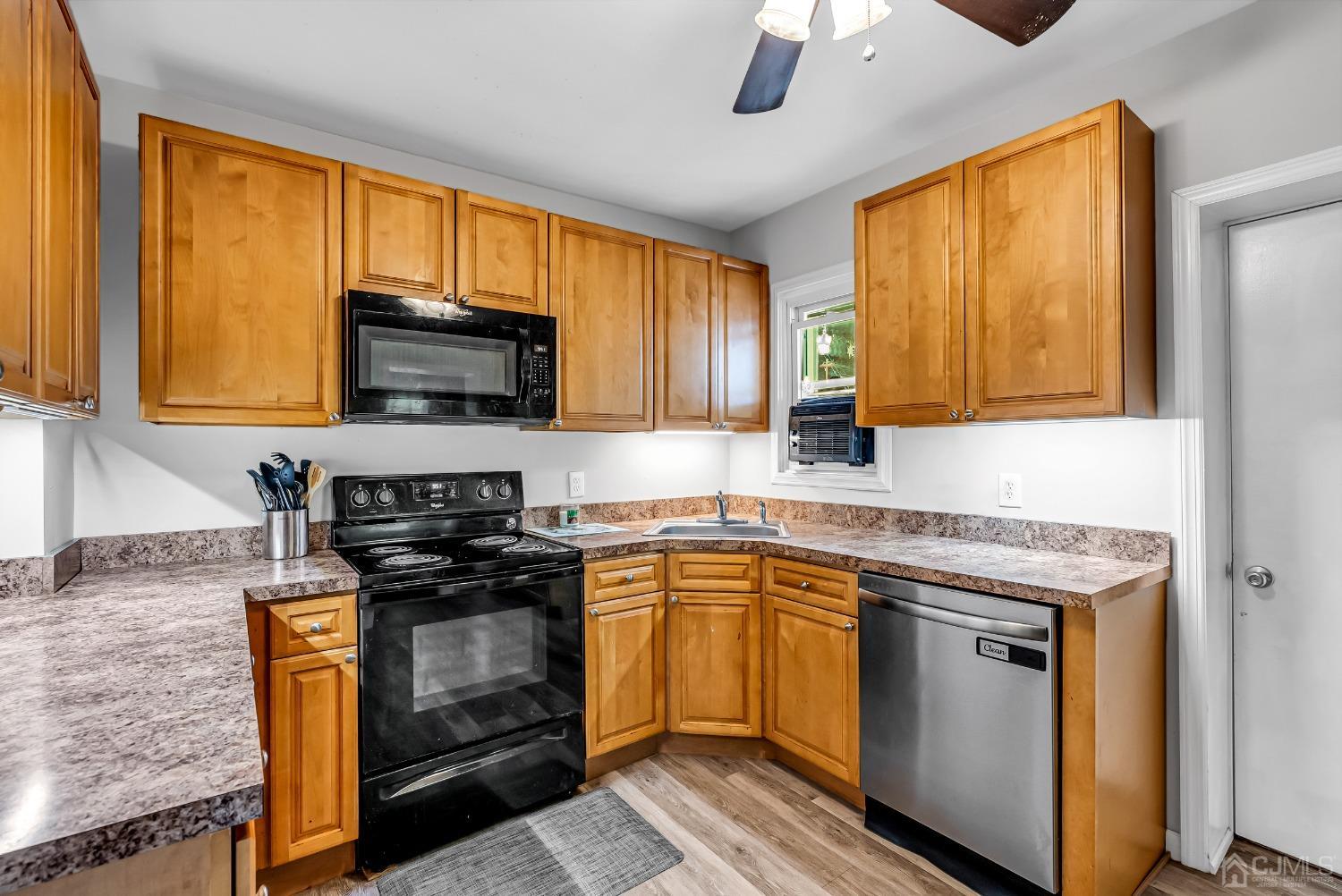 40 Farrington Road Old Bridge, NJ 07747 - Photo 12 of 49 a kitchen with stainless steel appliances granite countertop wooden cabinets a stove top oven a sink and dishwasher