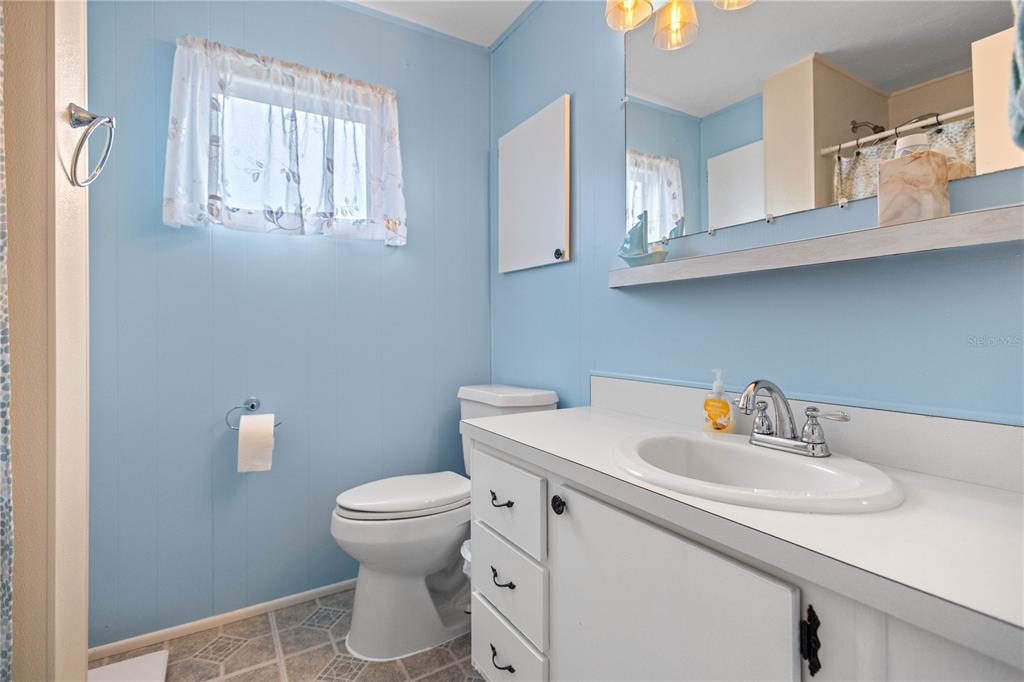 24437 Harbor View Road, Unit 55 Punta Gorda, FL 33980 - Photo 11 of 23 a bathroom with a sink a toilet and a mirror
