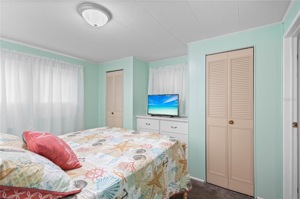 24437 Harbor View Road, Unit 55 Punta Gorda, FL 33980 - Photo 13 of 23 a bedroom with a bed and a flat screen tv