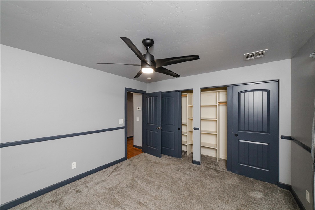3374 Roma Road Kingman, AZ 86401 - Photo 38 of 64 Unfurnished bedroom with two closets, carpet flooring, and ceiling fan