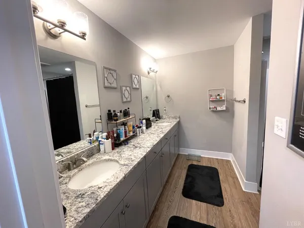 a bathroom with a granite countertop double vanity sink and mirror