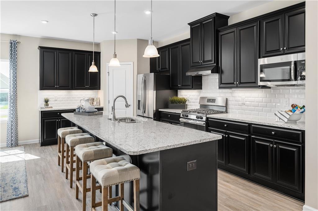 353 Dana Drive Eighty Four, PA 15330 - Photo 4 of 23 a kitchen with stainless steel appliances wooden cabinets a stove a sink and a microwave