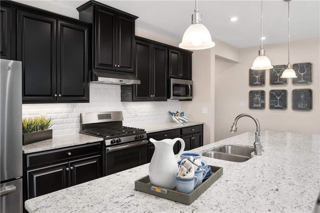 353 Dana Drive Eighty Four, PA 15330 - Photo 5 of 23 a kitchen with granite countertop a stove a sink and a microwave