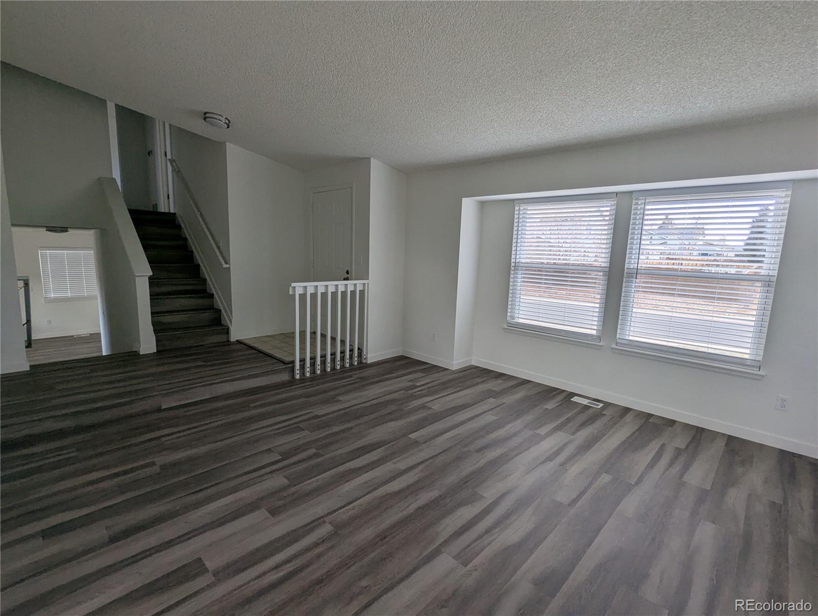 444 Spring Grove Avenue Highlands Ranch, CO 80126 - Photo 2 of 21 a view of an empty room with wooden floor and a window
