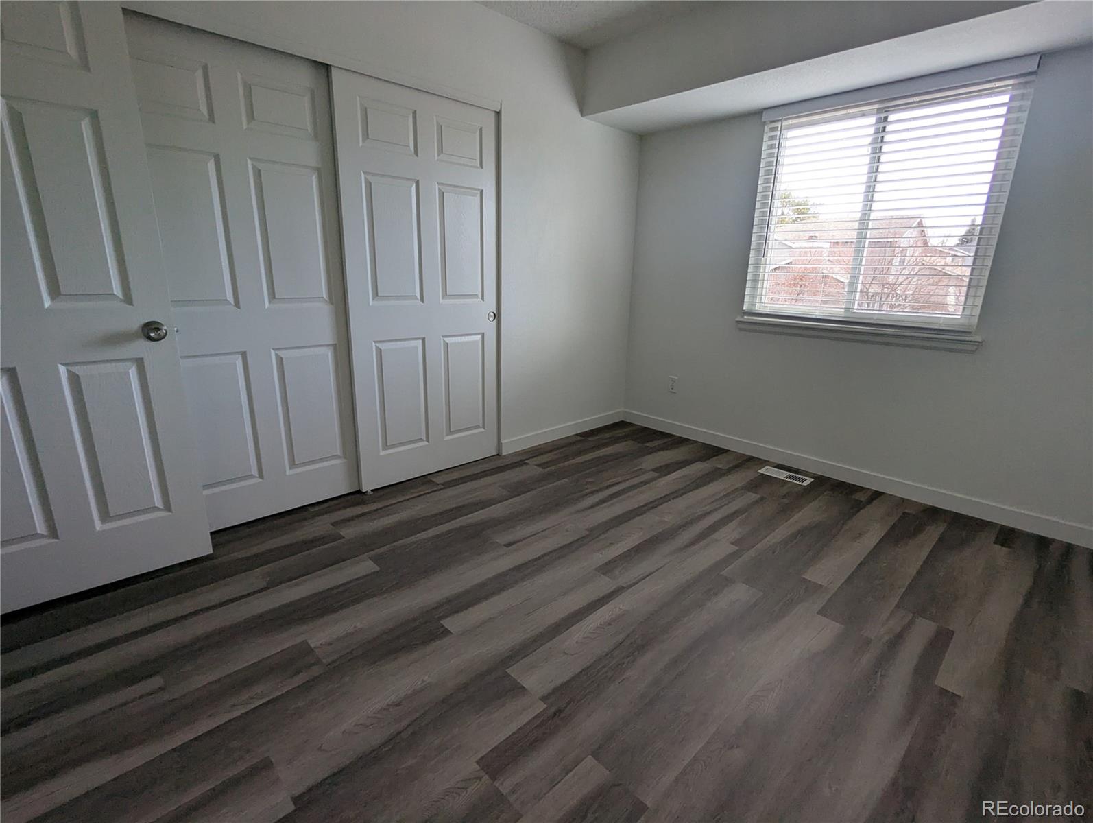 444 Spring Grove Avenue Highlands Ranch, CO 80126 - Photo 7 of 21 a view of an empty room with wooden floor and a window