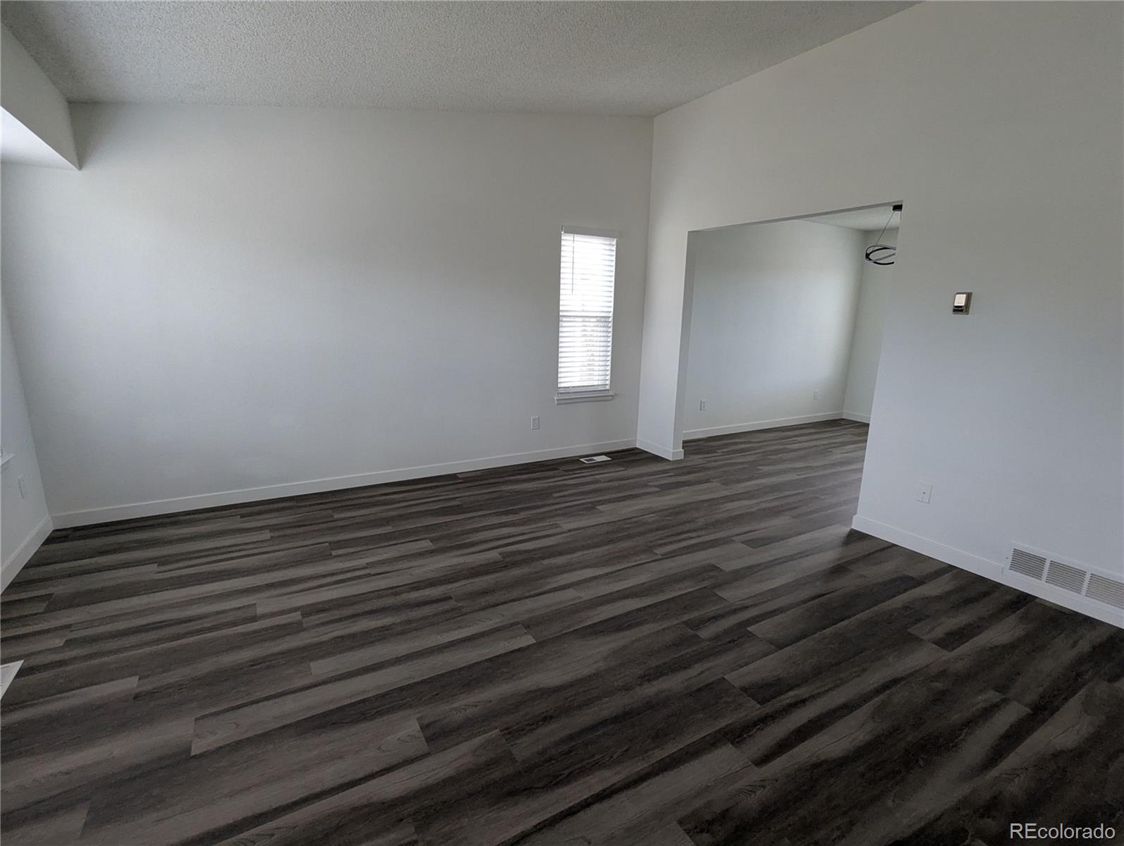 444 Spring Grove Avenue Highlands Ranch, CO 80126 - Photo 10 of 21 a view of an empty room with wooden floor and a window