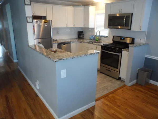 a kitchen with stainless steel appliances granite countertop a stove a sink and a refrigerator