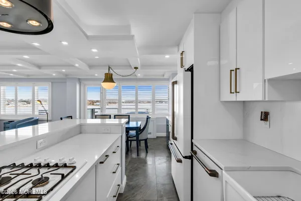 a living room with furniture kitchen view and a large mirror