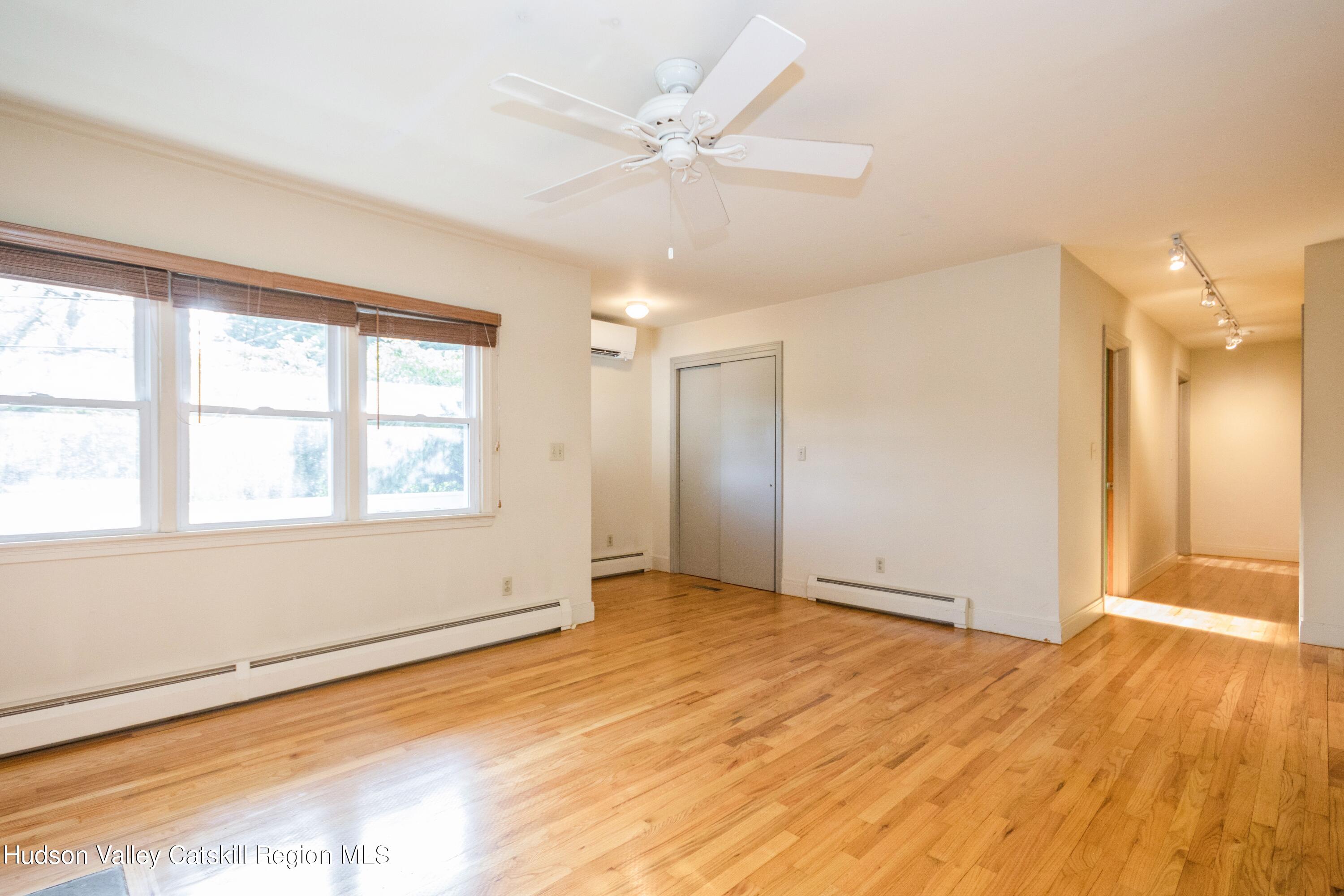 3754 Atwood Road Stone Ridge, NY 12484 - Photo 9 of 36 a view of an empty room with wooden floor and a window